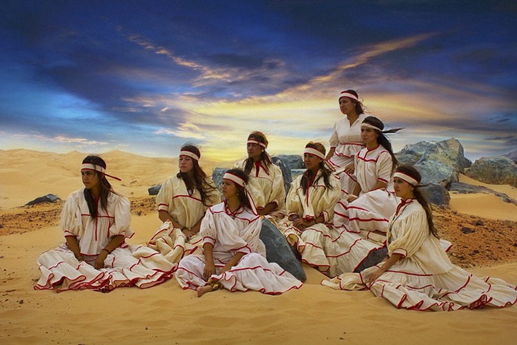 Группа мексиканцев в белых одеждах в лучах закатного солнца.