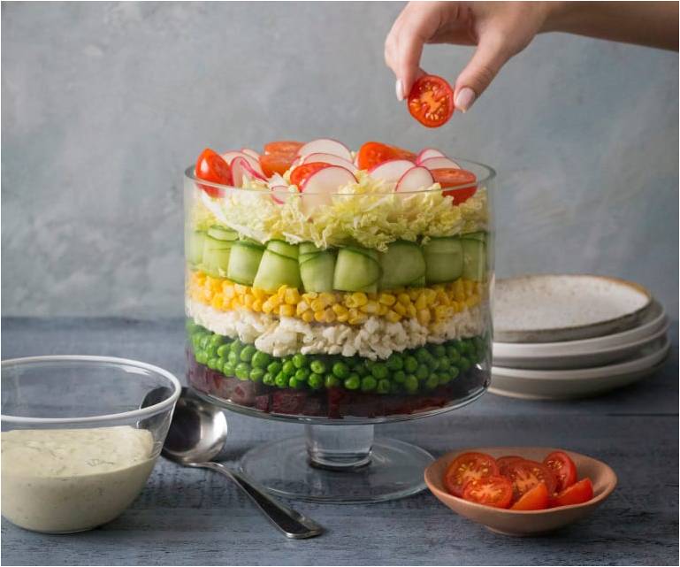 Овощи выложены слоями в салатнике.