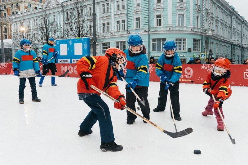 Дети играют в хоккей, отмечают день снега.